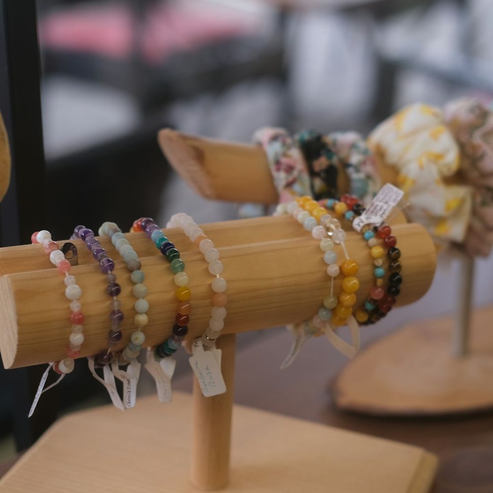 Pulseiras de bijuteria expostas em suportes de madeira